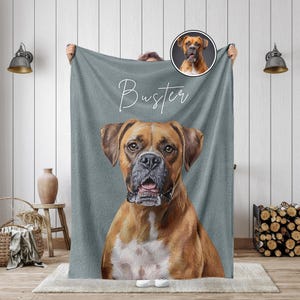 K&ouml;nnte beinhalten: Eine graue Decke mit einem detaillierten Portr&auml;t eines Boxerhundes mit braunem und wei&szlig;em Fell. Der Name des Hundes, "Buster", ist in Schreibschrift &uuml;ber dem Bild geschrieben. Ein kleineres kreisf&ouml;rmiges Bild des Hundes befindet sich in der oberen rechten Ecke.