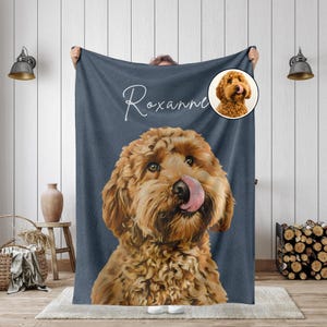 K&ouml;nnte beinhalten: Eine marineblaue Decke mit einem gro&szlig;en, detaillierten Bild eines Golden Doodle Hundes, der sich die Nase leckt. Der Name des Hundes, "Roxanne", ist in Schreibschrift &uuml;ber dem Hund geschrieben. Ein kleineres, kreisf&ouml;rmiges Bild des Hundes befindet sich in der oberen rechten Ecke.
