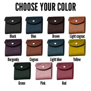 K&ouml;nnte beinhalten: Eine Auswahl an kleinen, quadratischen Geldb&ouml;rsen in verschiedenen Farben, darunter Schwarz, Blau, Braun und helles Cognac. Die Geldb&ouml;rsen haben einen Klappenverschluss mit einem Knopf. Der Text "CHOOSE YOUR COLOR" ist oben.