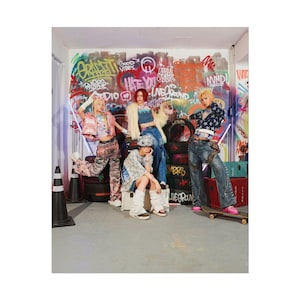 May include: A group of five people in a graffiti-covered room, wearing colorful, edgy streetwear. The background features vibrant graffiti art with phrases like "Good Vibes" and "Hate You." One person is on a skateboard, and another is wearing a denim jacket with star patterns.