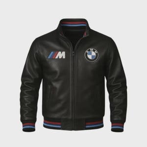 Op de afbeelding: Zwarte leren jas met ritssluiting, voorzien van het BMW-logo en het M-logo. Geribbelde kraag, manchetten en zoom met rood, wit en blauw gestreepte details. Een klassieke bomberjack-stijl.