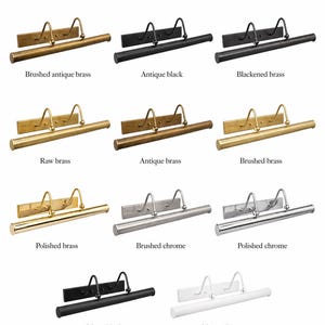 May include: A collection of eleven wall-mounted picture lights labeled Available Finishes. Each fixture features a rectangular backplate, two curved support arms, and a horizontal cylindrical light bar. Finishes include brushed antique brass, antique black, blackened brass, raw brass, antique brass, brushed brass, polished brass, brushed chrome, polished chrome, matte black, and matte white.