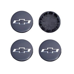 Peut inclure: Quatre enjoliveurs gris foncé avec le logo Chevrolet argenté. L'un des enjoliveurs est vu de dos, révélant le mécanisme de fixation. Les enjoliveurs sont ronds et ont une finition brillante. Pièces automobiles.
