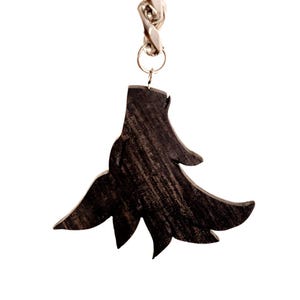May include: A dark brown wooden keychain pendant in the shape of a stylized tree. The pendant is suspended from a silver-colored chain and ring. The tree design has a textured, natural wood grain appearance.