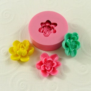 May include: A silicone mold for making small flower-shaped decorations, with three finished flowers in yellow, pink, and green.
