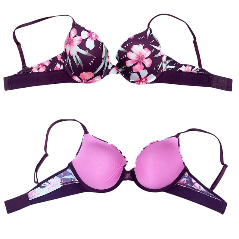 Puede incluir: Sujetador con estampado floral en tono morado oscuro, con flores rosas y blancas y hojas verdes. El sujetador tiene tirantes ajustables y cierre de corchete. El interior es de color rosa liso.