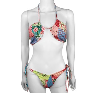 May include: A patchwork bikini set with a halter top and tie-side bottoms. The fabric features a mix of floral, polka dot, and geometric patterns in shades of red, blue, green, and pink. The bikini is displayed on a mannequin.