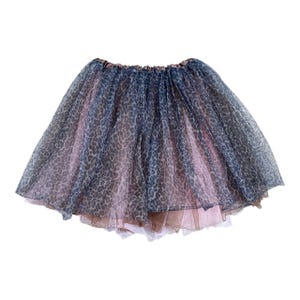 May include: A layered tutu skirt with a leopard print pattern in shades of blue, pink, and brown. The skirt has an elastic waistband and is made of sheer fabric. The skirt is designed for dance or costume.