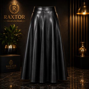 May include: A high-waisted, floor-length black skirt made of a smooth, leather-like material. The skirt features a structured waistband and a flared, A-line silhouette with vertical panel seams that create deep, flowing pleats throughout the garment.