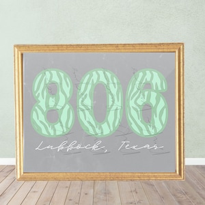 May include: A framed print with a grey background and a green zebra print design. The numbers 806 are printed in the zebra print design. The text "Lubbock, Texas" is printed below the numbers.