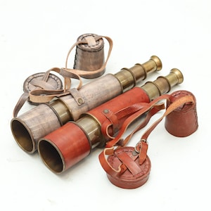 May include: Three antique brass and leather telescopes with matching leather cases. One telescope is wrapped in brown leather, another in reddish-brown leather, and the third in a light brown leather. Each telescope has a leather strap.