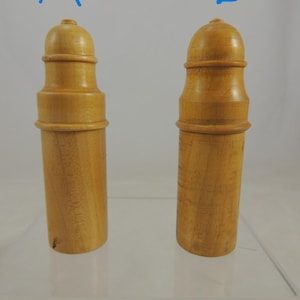 May include: Two wooden salt and pepper shakers with a dome-shaped top and a cylindrical body.