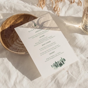 May include: A printed dinner menu on white paper with a green tree design. The menu includes appetizers, entrees, main courses, and dessert options. A rustic ceramic bowl is in the background.
