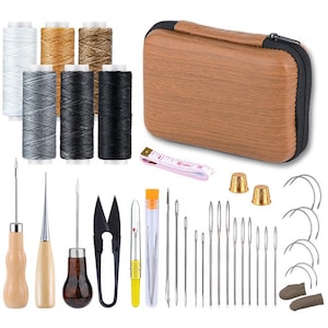 May include: A sewing kit with various tools and supplies. The kit includes spools of thread in white, gold, and black, along with needles, scissors, thimbles, and a measuring tape. The kit is stored in a brown case.