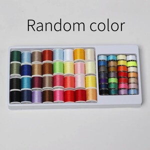 以下が含まれることがあります： 緑、青、茶色、ピンクなど、さまざまな色の糸巻きが入った白いプラスチックトレイ。 トレイの上には「Random color」の文字が表示されています。