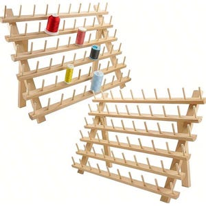 Op de afbeelding: Twee houten garenkloshouders, elk met meerdere rijen pinnen om klosjes garen vast te houden. De houders zijn gemaakt van lichtgekleurd hout en zijn gevuld met kleurrijke garenklosjes in rood, roze, blauw, geel en blauwgroen.