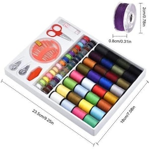 Puede incluir: Un kit de costura en una bandeja blanca, con una variedad de carretes de hilo coloridos, agujas, tijeras y otras herramientas de costura. La bandeja mide 23,5 cm de largo y 18 cm de ancho. También se muestra un carrete de hilo morado, que mide 2 cm de diámetro.