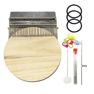 May include: A wooden circular weaving loom with metal components, accompanied by black hair ties, colorful stitch markers, needles, and a hook. The loom has a natural wood finish and is designed for crafting.