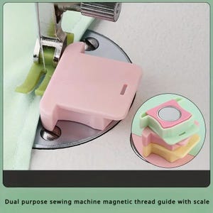 Könnte beinhalten: Eine hellrosa magnetische Nahtführung für Nähmaschinen auf einer Metallstichplatte neben einem hellgrünen Nähfuß. Ein kreisförmiger Ausschnitt zeigt einen Stapel aus drei magnetischen Führungen in Rosa, Hellgrün und Gelb mit Magneten.