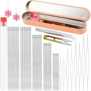 May include: A sewing kit with various needles, tweezers, and scissors. The kit includes a clear tube with a red cap, a peach-colored case, and pink flower-shaped needle threaders. The scissors have orange and green handles.