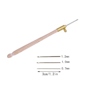 Könnte beinhalten: Ein Stickwerkzeug mit Holzgriff, Messinghülse und Stellschraube. Enthält drei austauschbare Metallnadelspitzen mit den Bezeichnungen 1,2 mm, 1,0 mm und 0,7 mm sowie eine Skala, die eine Referenzlänge von 3 cm für die Nadeln anzeigt.