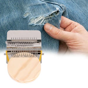 May include: A silver-colored denim repair tool with a yellow accent, and a stack of small, round, wooden patches. The tool is designed to weave threads for mending torn denim. The image shows the tool next to a pair of distressed blue jeans.