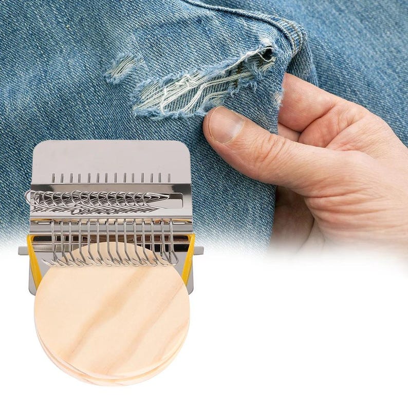 May include: A metal weaving tool with a stack of wooden circles, used for repairing denim. The tool has a silver frame with hooks and a yellow accent. The denim has a distressed look with a tear.