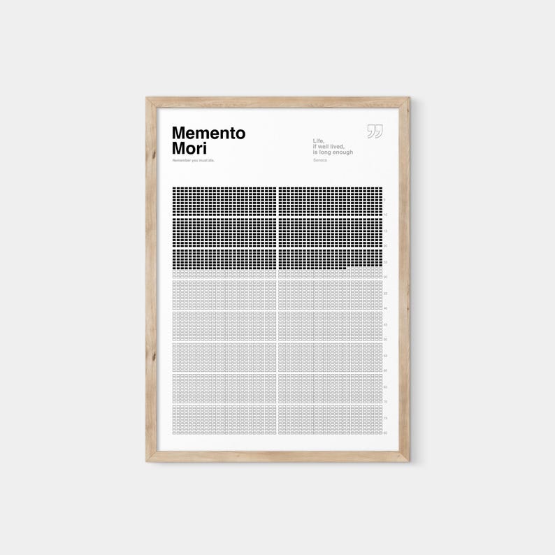 May include: A framed print with the words "Memento Mori" and a quote about life. The print features a grid design with black and gray squares. The frame is made of light-colored wood.
