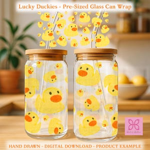 May include: Two clear glass tumblers with bamboo lids and glass straws, featuring a repeating pattern of yellow rubber ducks with orange beaks. The text Lucky Duckies - Pre-Sized Glass Can Wrap appears at the top, with Hand Drawn - Digital Download - Product Example at the bottom.