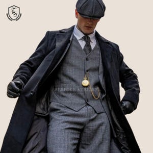 May include: A grey three-piece suit with a long black overcoat, a matching flat cap, and black gloves. A gold pocket watch hangs from the vest. The text "BESPOKE ATELIER LONDON" is visible.