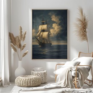 May include: A framed nautical painting depicts a tall ship sailing on a dark blue sea under a cloudy sky. The artwork features a gold frame and is displayed in a room with neutral tones and decorative elements.