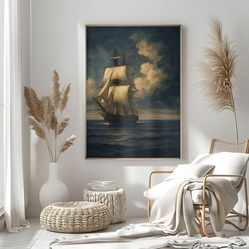 May include: A framed nautical painting depicts a tall ship sailing on a dark blue sea under a cloudy sky. The artwork features a gold frame and is displayed in a room with neutral tones and decorative elements.