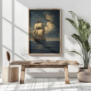May include: A framed nautical painting depicts a tall ship sailing on a dark blue sea under a cloudy sky. The artwork features a wooden frame and is displayed above a rustic wooden bench.