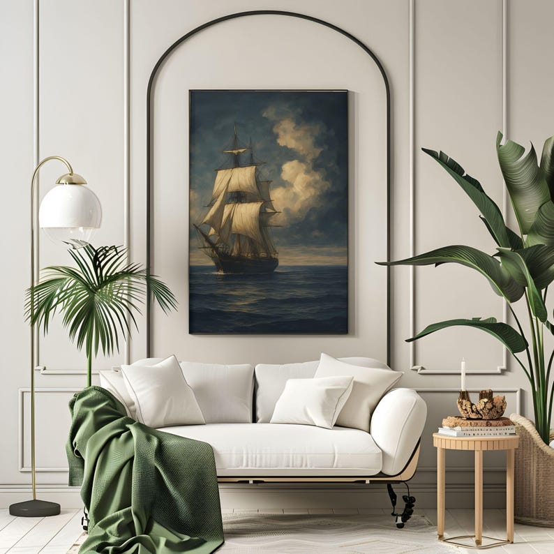 May include: A framed painting of a tall ship sailing on a dark blue sea under a cloudy sky. The artwork is displayed above a white sofa with green throw and pillows. A floor lamp and potted plants are in the foreground.