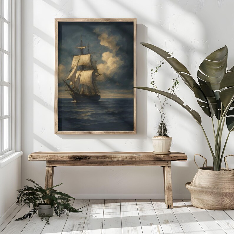 May include: A framed print of a tall ship sailing on a dark blue sea under a cloudy sky. The artwork is in a wooden frame and hangs on a white wall. The scene evokes a sense of adventure and maritime history.