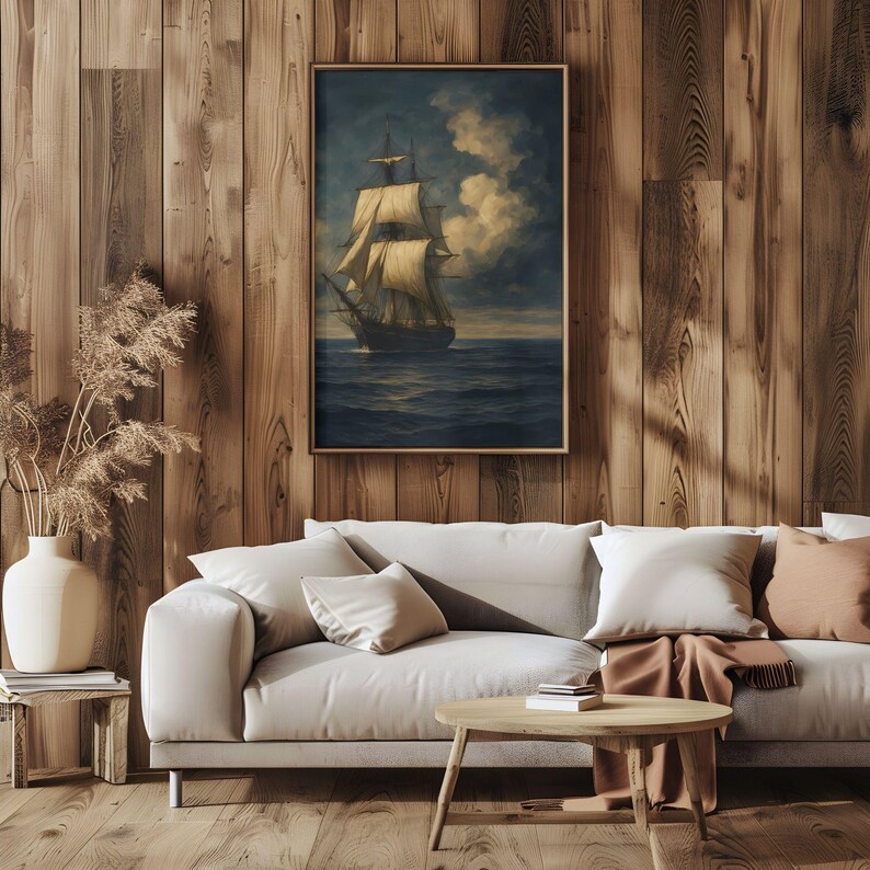 May include: A framed nautical painting depicts a tall ship sailing on a dark blue sea under a cloudy sky. The artwork is displayed on a wooden wall above a light-colored sofa with pillows and a wooden coffee table, creating a cozy living room setting.