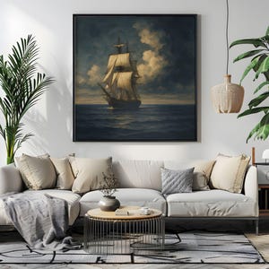 May include: A framed nautical painting depicts a tall ship sailing on a dark blue sea under a cloudy sky. The artwork features a black frame and is displayed above a white sofa with beige pillows, enhancing the room's decor.