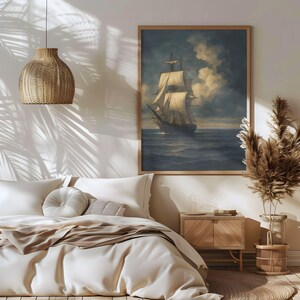 May include: A framed nautical art print depicts a tall ship sailing on a dark blue sea under a cloudy sky. The artwork is in a wooden frame and hangs above a bed with white bedding. A woven pendant light and decorative plants are also in the room.