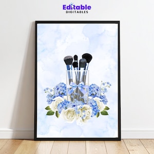 May include: A framed print featuring makeup brushes in a clear glass, tied with a blue ribbon, surrounded by blue hydrangeas and white roses. The background has a watercolor effect with blue hues. The text "Editable Digitables" is at the top.