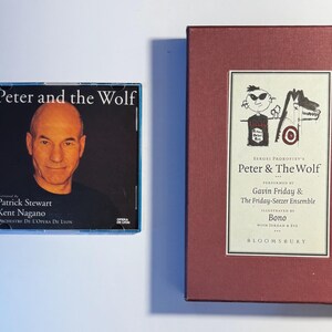 Peut inclure: Un boîtier de CD et un coffret bordeaux de "Pierre et le Loup". Le CD présente Patrick Stewart. Le coffret contient une illustration et les noms de Gavin Friday et Bono. Le coffret est de Bloomsbury.