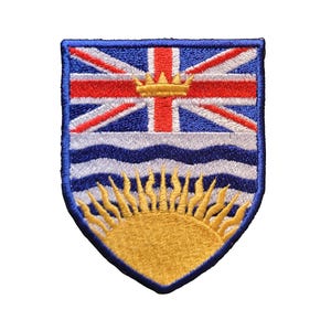 Puede incluir: Parche bordado con la bandera de la Columbia Británica. El diseño incluye la Union Jack, una corona dorada, líneas onduladas azules y un sol dorado. El parche tiene un borde azul y es probablemente para ropa o accesorios.