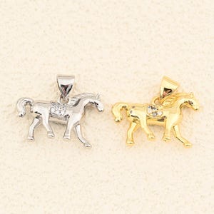 Ciondolo a forma di cavallo al galoppo in oro 18 carati con piccole pietre scintillanti, perfetto per un look sofisticato di tutti i giorni. Dimensioni: 13,5 x 20 mm.