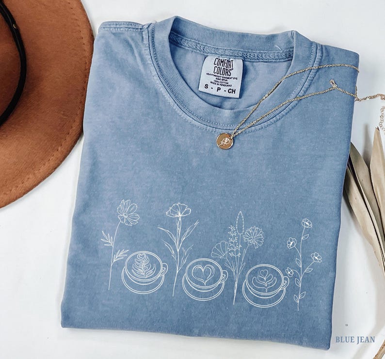 Minimalist botanical line art with coffee cups printed in cream ink on an Blue Jeans Comfort Colors t-shirt. Aesthetic coffee lover apparel.