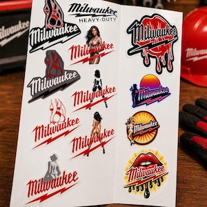 May include: A sheet of stickers featuring the "Milwaukee" logo in various designs. Some stickers include illustrations of women, while others showcase the brand's name with lightning bolts and a sunset graphic. The stickers are red, black, and white.