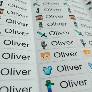 May include: A sheet of rectangular white adhesive labels featuring the name Oliver printed in black sans-serif font. Each label includes a small, colourful pixelated graphic inspired by Minecraft, such as swords, pickaxes, and various game characters.