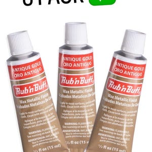May include: Three tubes of Antique Gold Rub 'n Buff wax metallic finish, each containing 15 ml. The tubes are brown with red and white labels. The text "3 PACK" and a green checkmark are at the top.