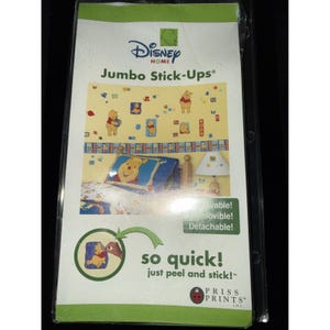 May include: A package of Disney Home Jumbo Stick-Ups featuring Winnie the Pooh. The package shows a bedroom scene with Pooh Bear decals, a pillow, and a lamp. The text reads "so quick! just peel and stick!"