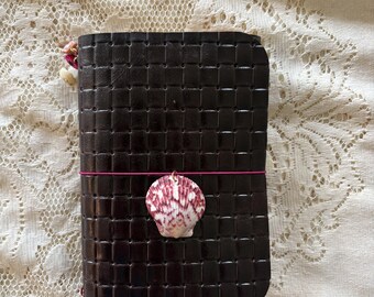Agenda a tre ante in pelle intrecciata e goffrata, formato A6, colore marrone cacao, con motivo a conchiglia, porta passaporto e taccuino da viaggio ispirato a Louise Carmen.