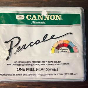 May include: White packaging for a Cannon Monticello Percale full flat sheet. The packaging features a green and white label with the text "Cannon Monticello Percale" and a rainbow-colored graphic with the text "Common Sense". The packaging also includes the text "No Iron Luxury Percale - 180 Thread Count 50% Combed Cotton (Coton)/50% Fortrel® Polyester One Full Flat Sheet Finished Size 81 x 96 in. (205 x 243 cm) Fits Mattress 54 x 75 in. (137 x 190 cm)"
