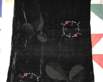 May include: Black velvet scarf with embroidered floral designs and rhinestones. The design features two pink flowers and leaves.
